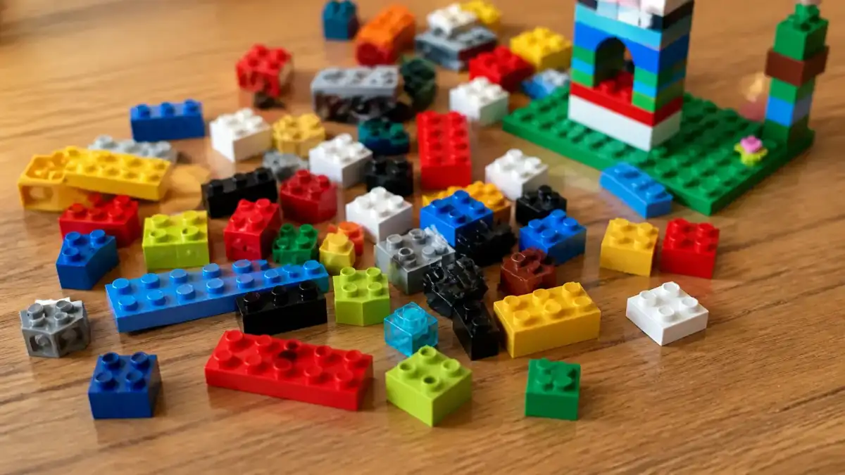 תמונה של קוביות LEGO צבעוניות על שולחן עץ